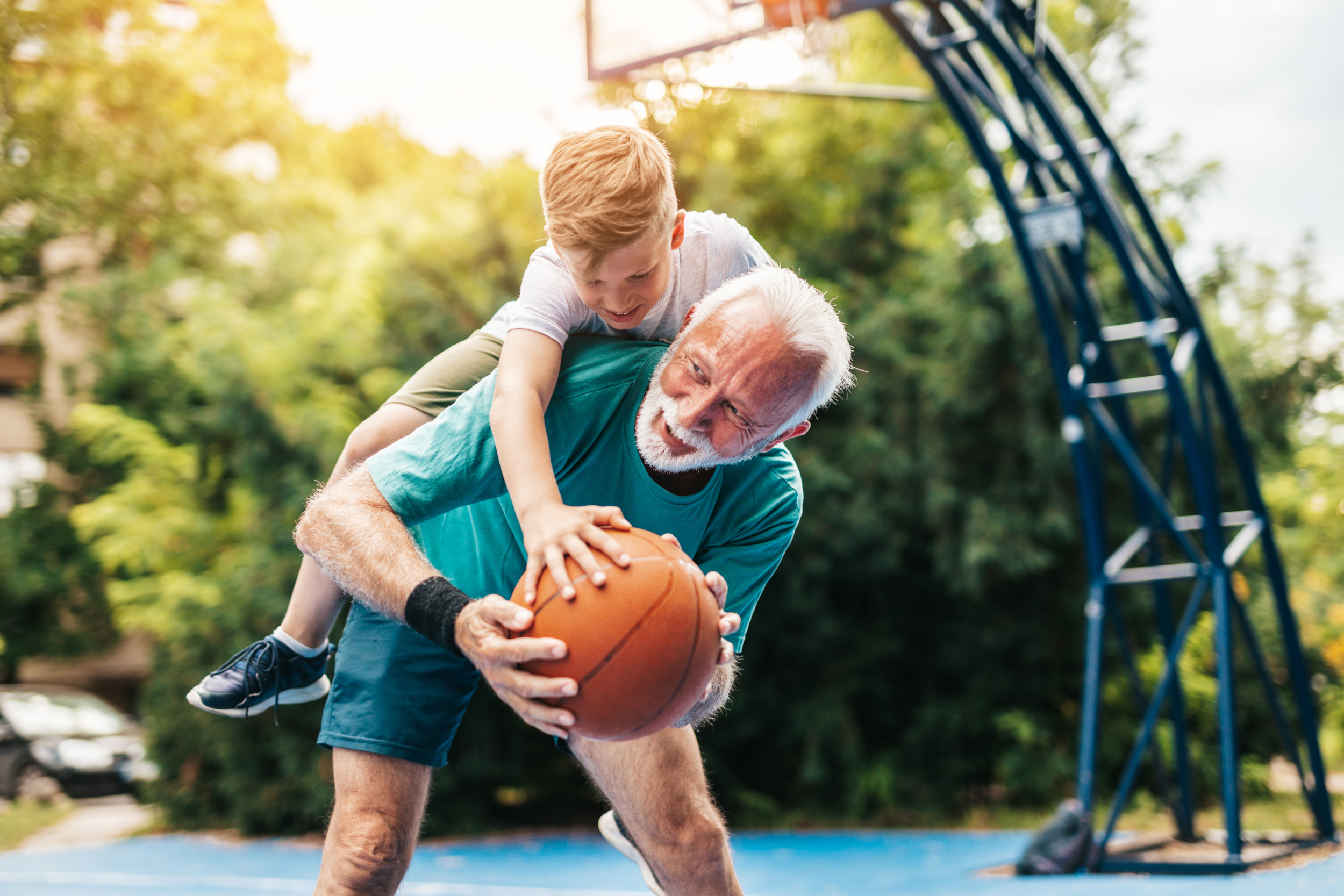 Opa und Enkel spielen gemeinsam mit einem Basketball