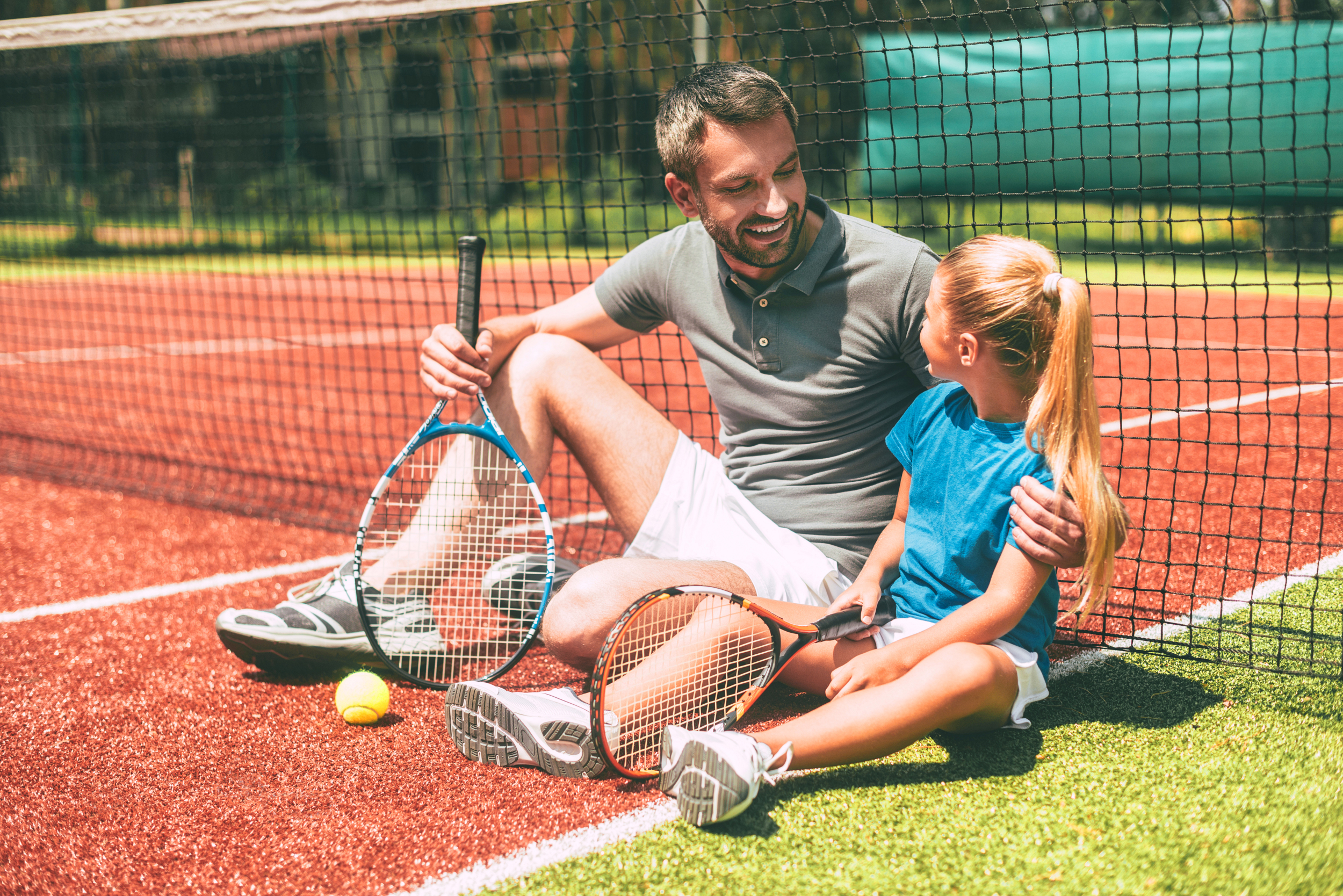 Papa spielt mit seiner Tochter Tennis