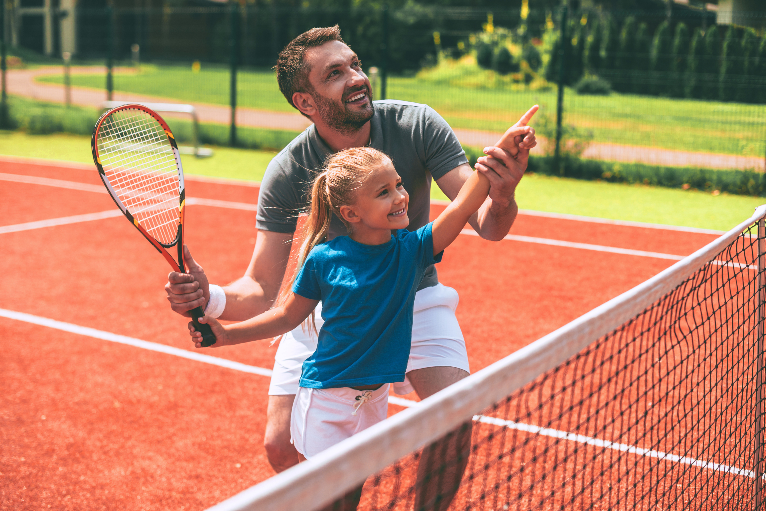 Vater und Tochter spielen gemeinsam Tennis